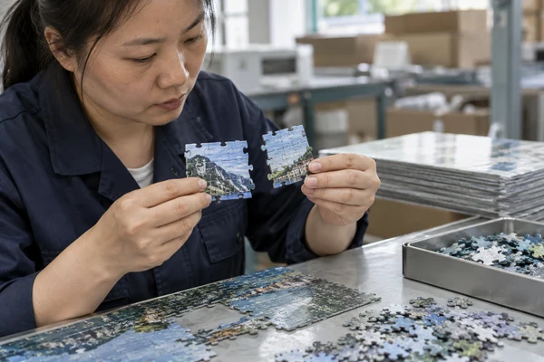 Asian adult quality reviewer comparing piece fit in two small assembled sections