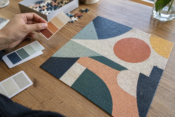 close-up of color patches beside a completed abstract geometric cardboard puzzle